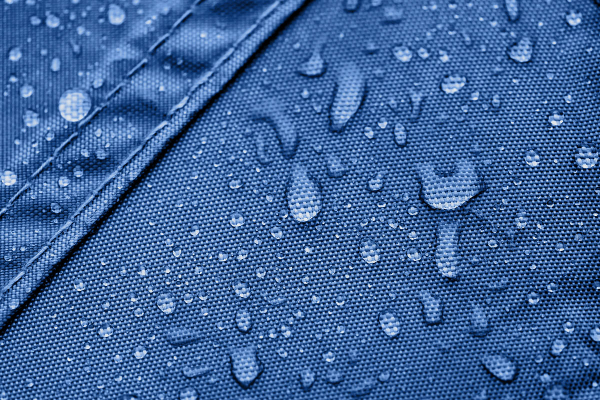 Detailaufnahme von Wassertröpfchen auf dem blauen Material des Vento Aufblasbaren Zeltes B1, das wasserabweisend ist.