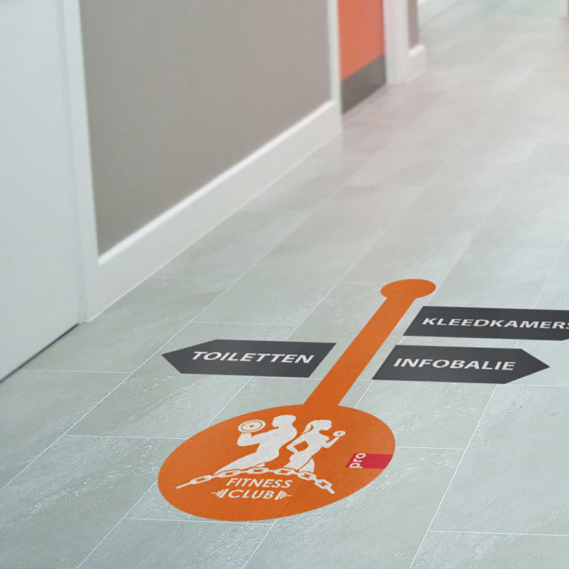 Fußbodenaufkleber mit Wegweisern zu Toiletten, Umkleideräumen und Infobereich im Fitnessclub.