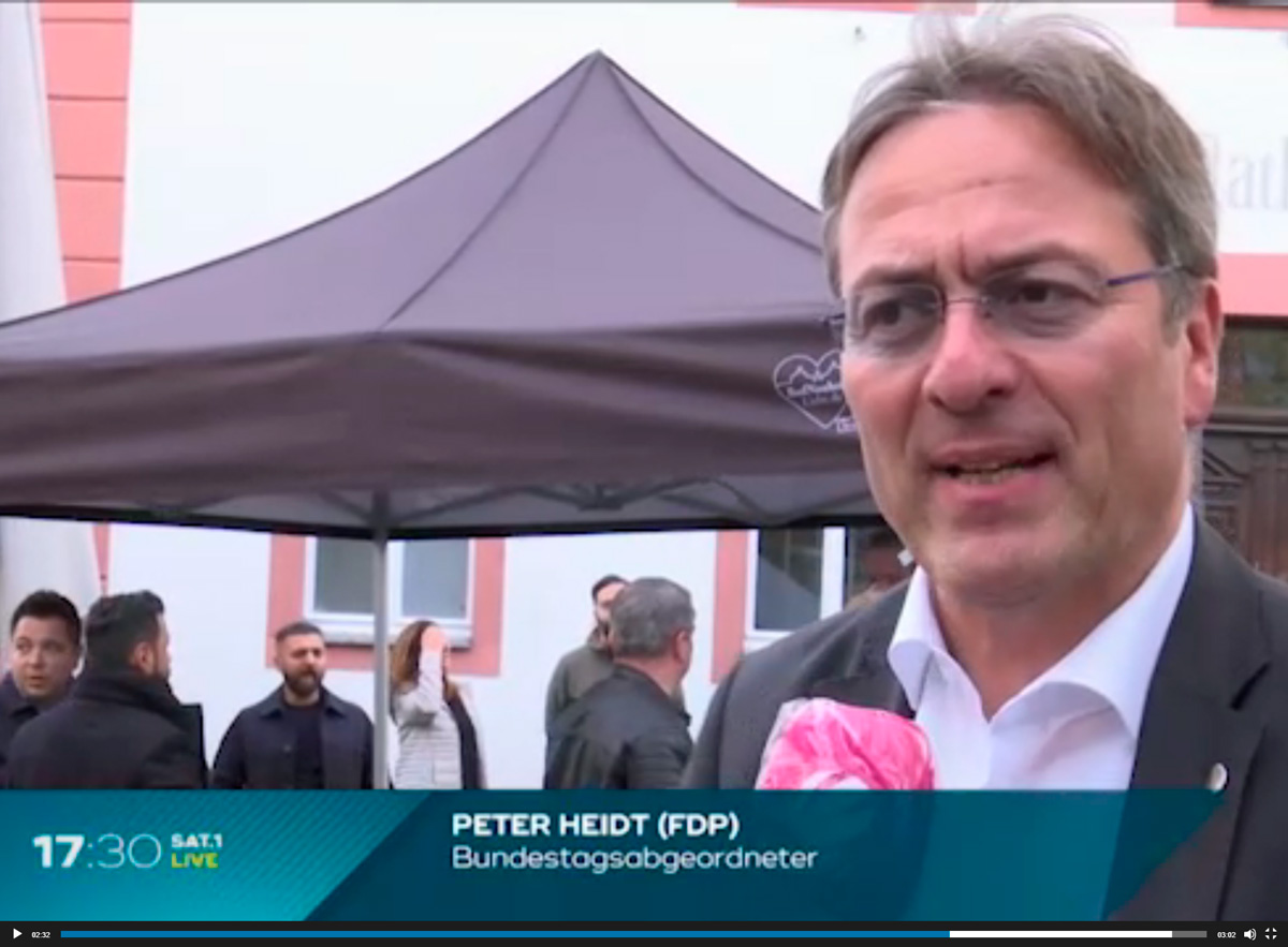 Peter Heidt, Bundestagsabgeordneter der FDP, spricht vor einem Zelt bei einer Veranstaltung.