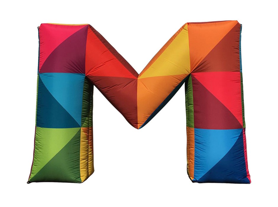 Bunte, aufblasbare Buchstaben 'M' in verschiedenen Farben und geometrischen Mustern.