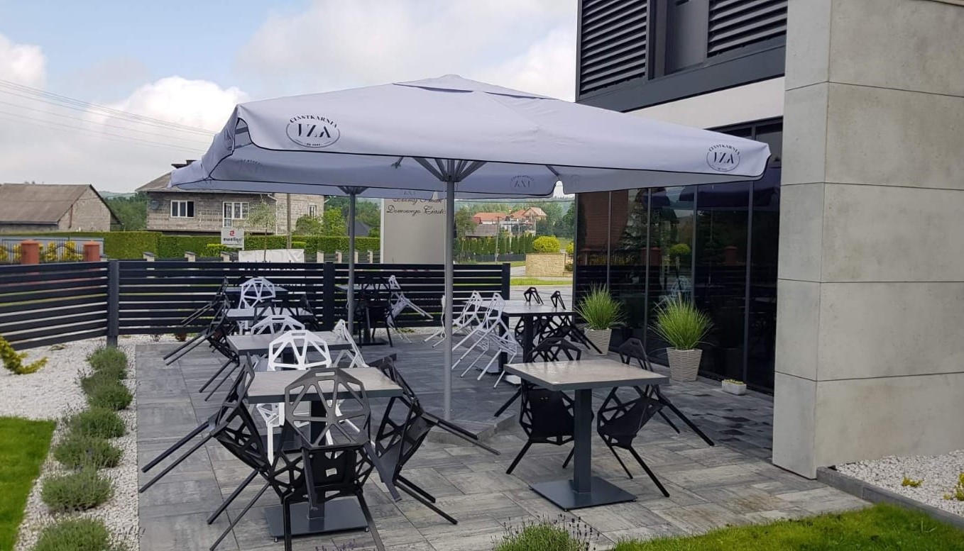 Sonnenschirm 13 von ENTDECKER auf einer Terrasse mit Tischen und Stühlen.