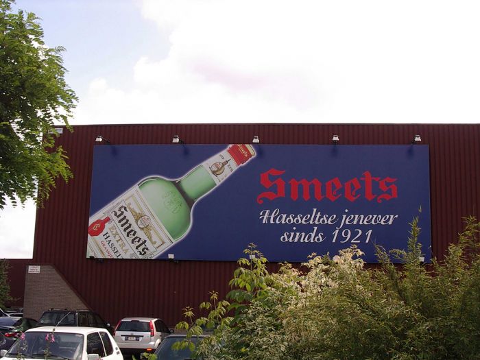 Banner mit der Aufschrift 'Smeets Hasseltse jenever seit 1921' und einer Abbildung einer Flasche.