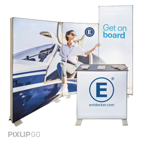 Messeaufbau mit Pixlip Go Produkten, einer beleuchteten Theke und großflächigen Grafiken, die eine Person im Flugzeug zeigt.