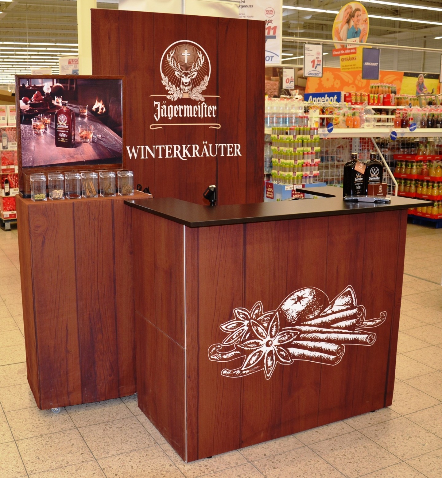 Messetheke von Jägermeister mit Holzoptik, präsentiert Winterkräuter, ausgestattet mit Monitor und Produktpräsentation.