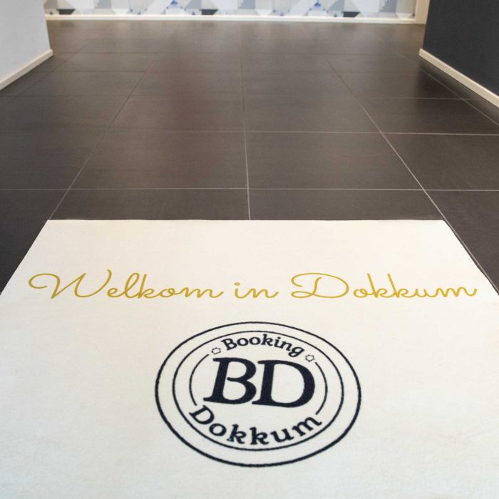 Fußmatte mit dem Text 'Welkom in Dokkum' und dem Logo 'Booking Dokkum' in der Mitte.