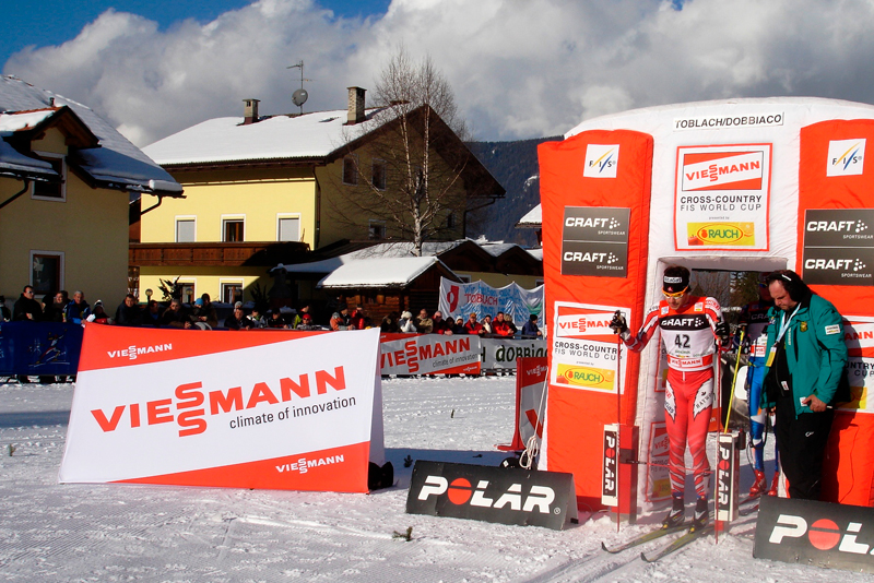 Werbebande für das Produkt 'Clickboard Winter' von ENTDECKER, präsentiert bei einem Skirennen mit Zuschauern im Hintergrund.