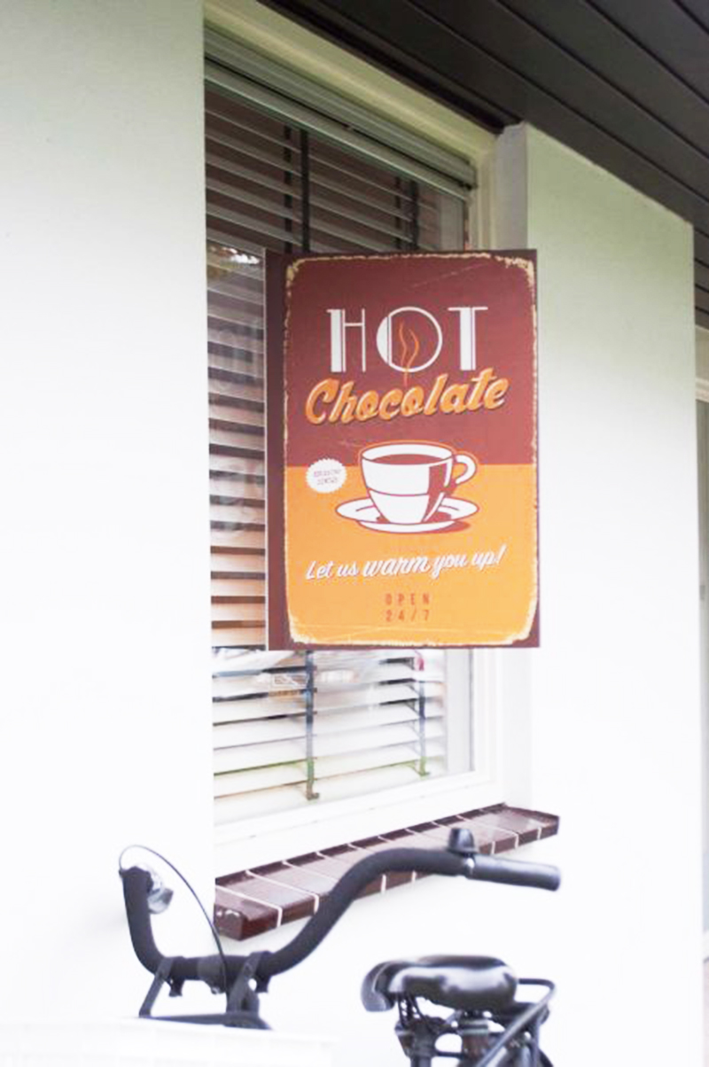 Bedrucktes Fensterschild mit der Aufschrift HOT Chocolate und dem Slogan Let us warm you up!