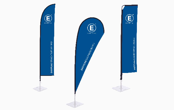 Drei blaue Fahnen mit dem Logo 'E' auf weißen Ständern, Modell Easyflag Pro Ausführung Stoff.