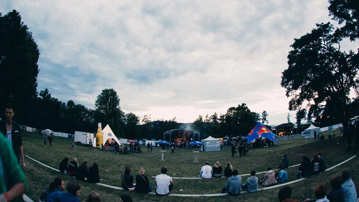 Festivalgelände des 'Born In The Wetterau Soundgarden Festivals' mit Zuschauern, Zelten und einer Bühne im Hintergrund.