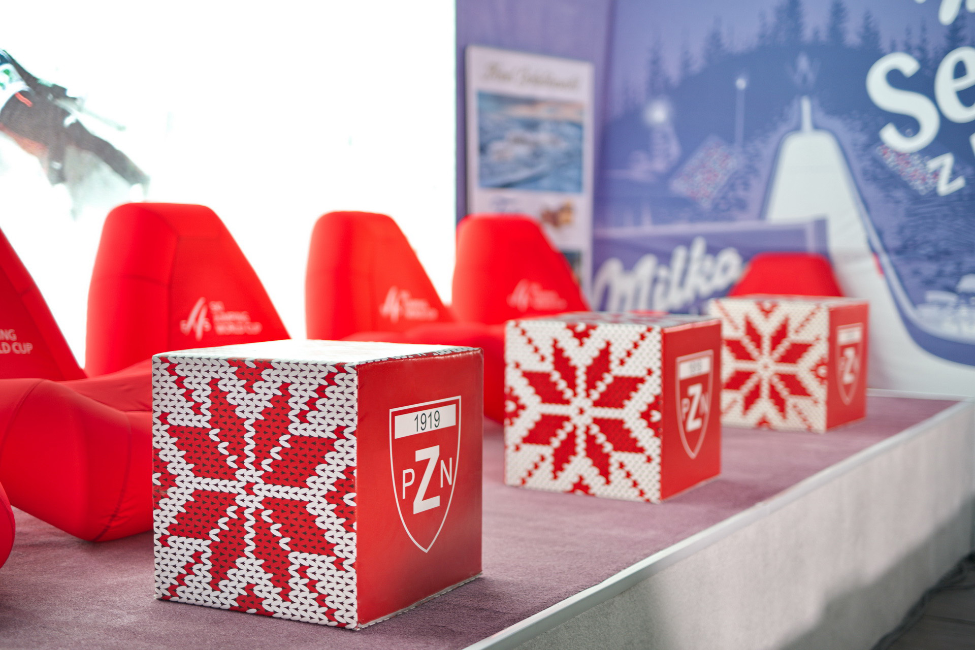 Rote Mitko-Würfel-Stühle und dekorative Würfel mit PZN-Logo auf einem Event.