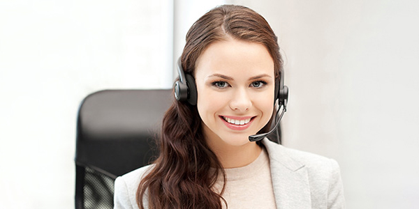 Kundendienstmitarbeiterin mit Headset, lächelnd, in einem modernen Büro.
