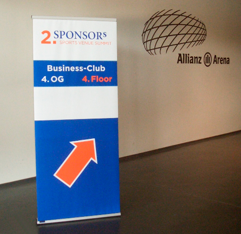 Rollup-Banner für den 2. Sponsors Sports Venue Summit mit Hinweis auf den Business-Club im 4. OG der Allianz Arena.