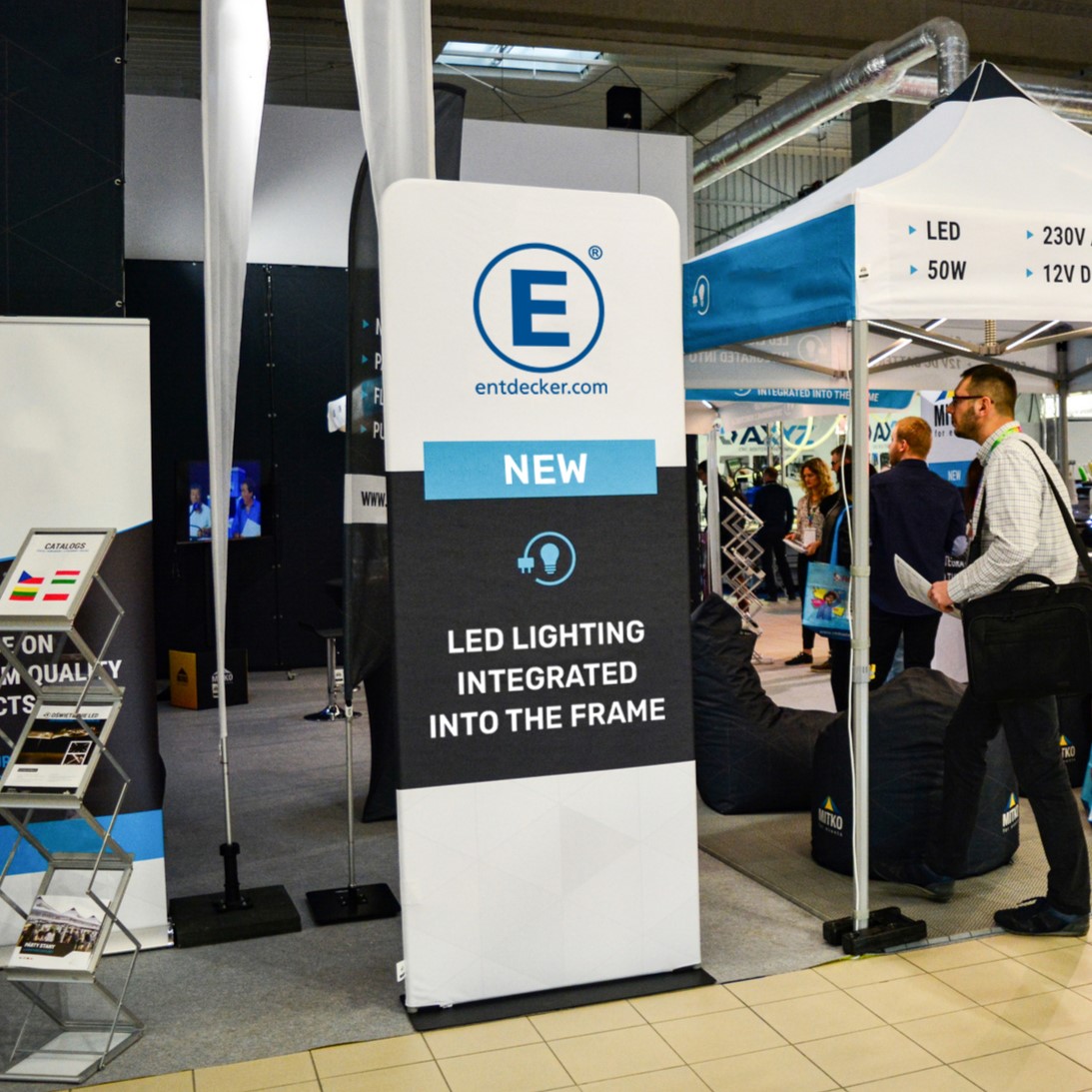 Messestand mit einem Banner für das Produkt 'Zipper Wall Messe' von ENTDECKER, das integrierte LED-Beleuchtung anzeigt.