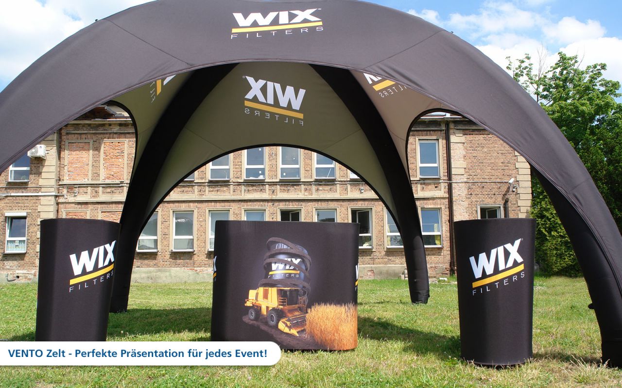 Aufblasbares Zelt von WIX mit dem Produktnamen 'Vento' und Werbematerial für Filterprodukte, auf einer Wiese vor einem Gebäude.