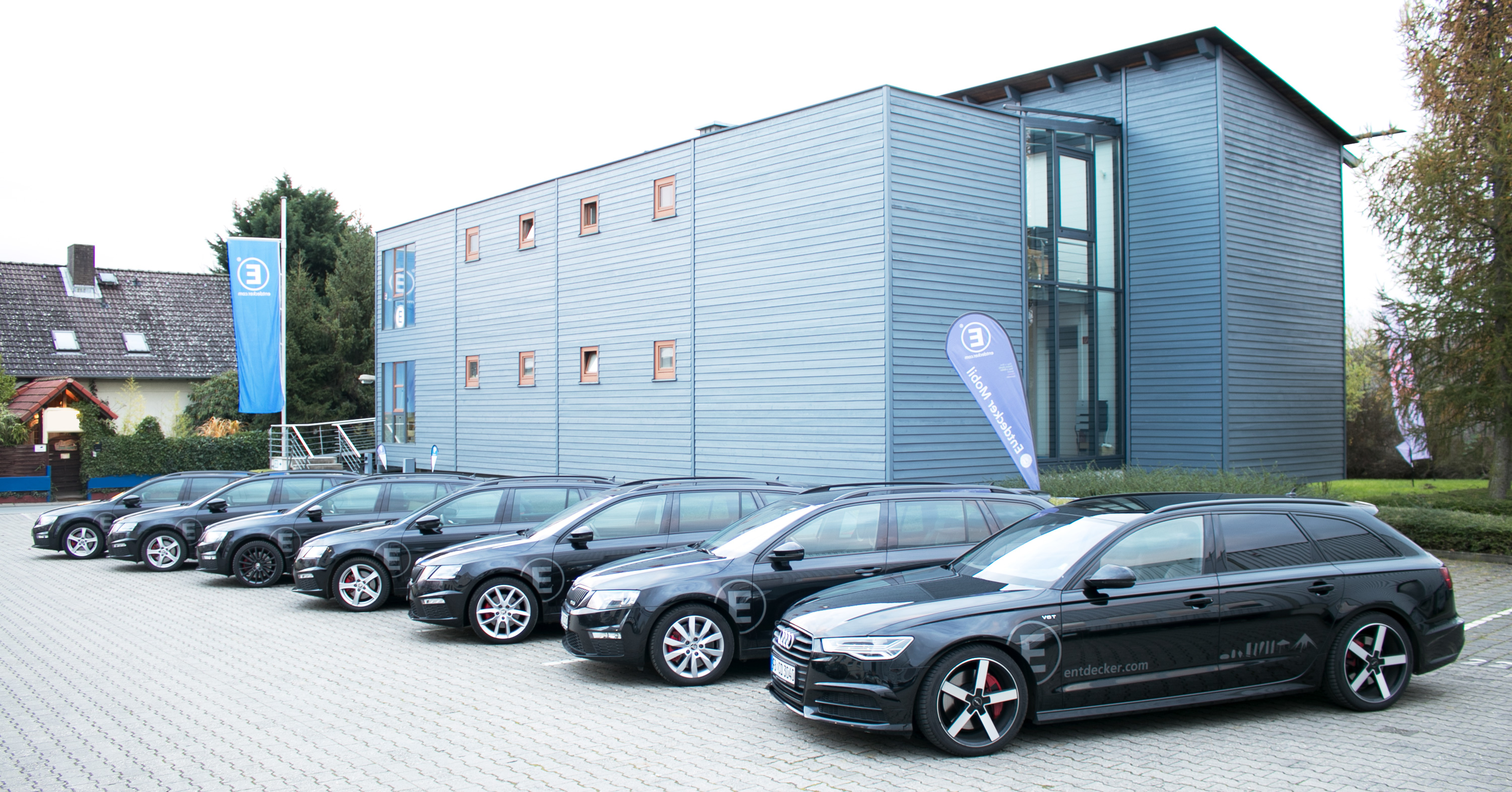 Flotte von schwarzen Fahrzeugen vor dem Gebäude der Entdecker GmbH in Rosbach.