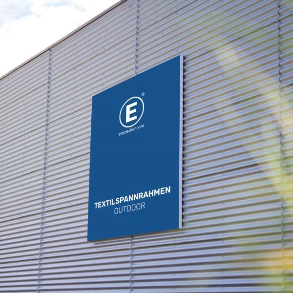 Textilspannrahmen Outdoor von ENTDECKER, montiert an einer Wand, mit blauem Hintergrund und weißem Text.
