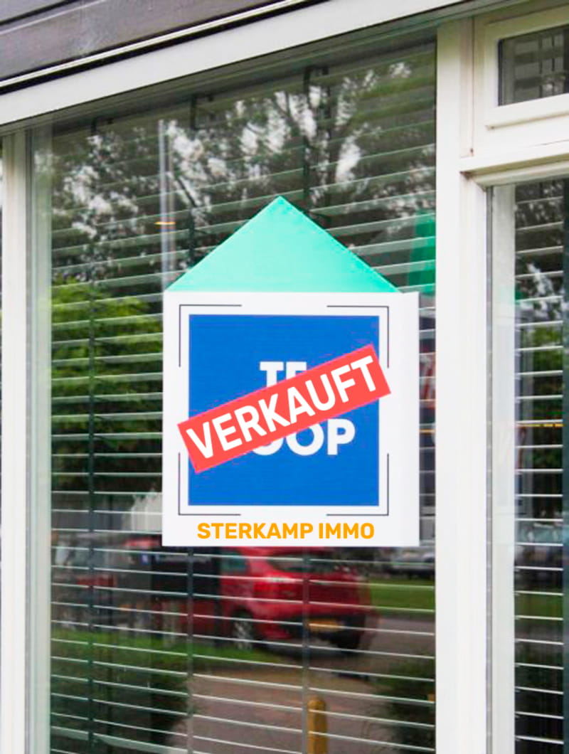 Maklerschild mit der Aufschrift VERKAUFT und dem Logo STERKAMP IMMO, angebracht an einem Fenster.