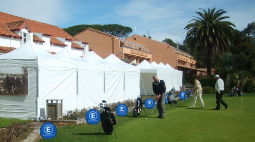 Werbedisplay Easydisc Flex in Bodenmontage auf einem Golfplatz mit Golfern und Zelten im Hintergrund.
