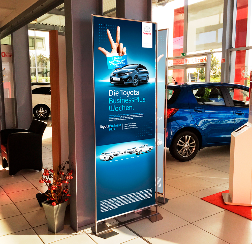 Werbeschild für die Toyota BusinessPlus Wochen mit Informationen zu Angeboten und Fahrzeugen.