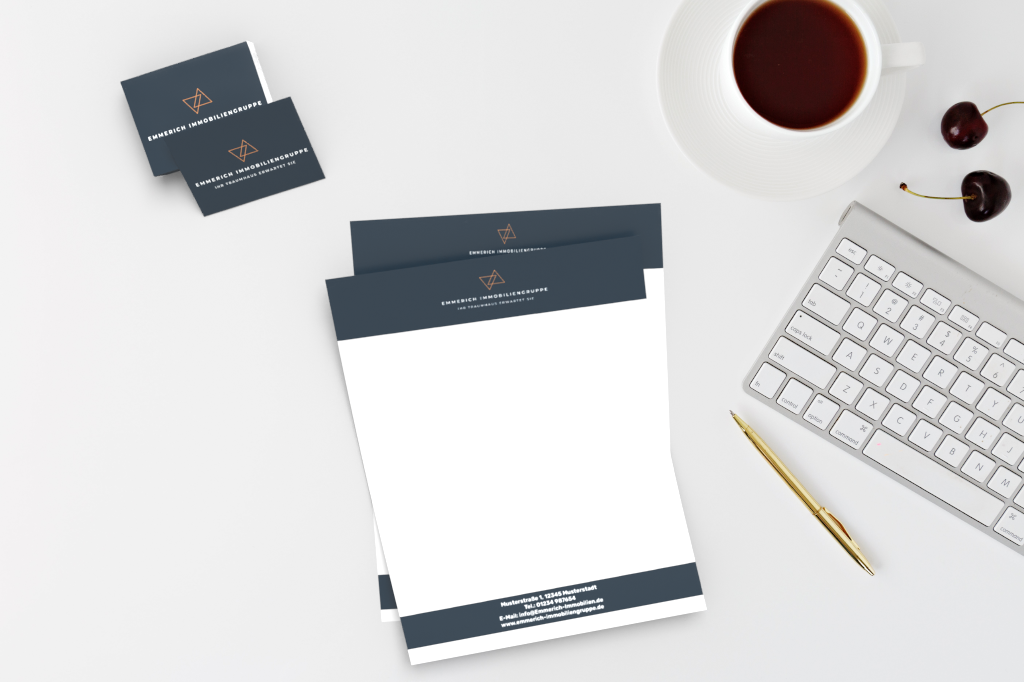 Schreibtisch mit Drucksachen, darunter Briefpapier und Visitenkarten, sowie einer Tasse Kaffee und einer Tastatur.