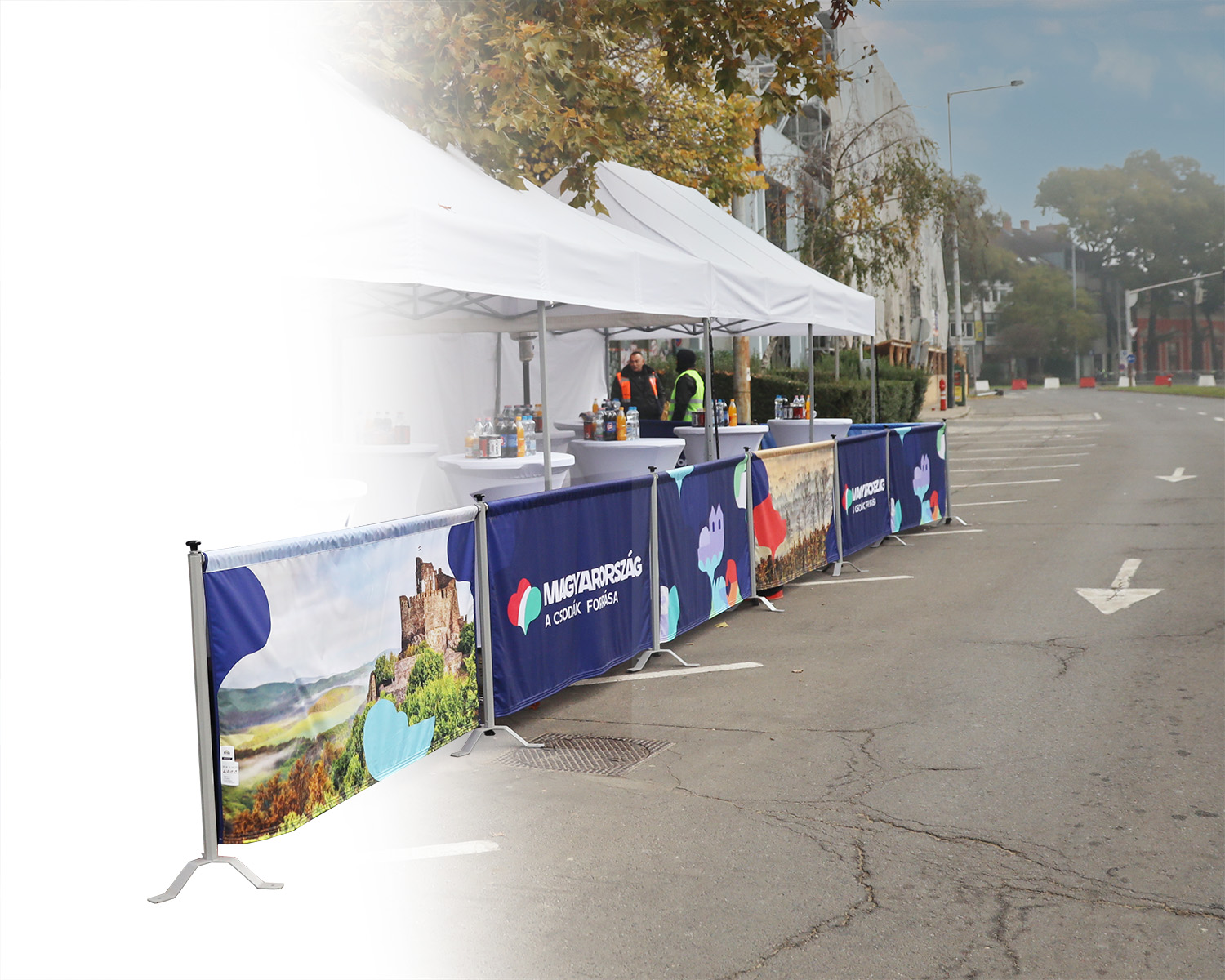 Rennsportbande in Reihe mit bunten Grafiken, auf einer Straße aufgestellt, um einen Eventbereich abzugrenzen.