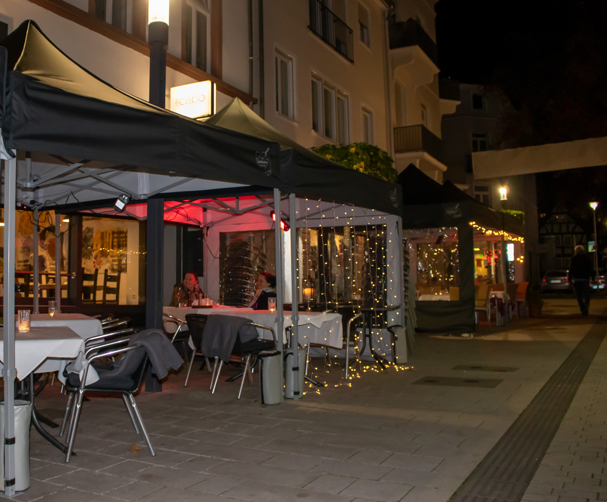 Beleuchtete Zeltaktionen für Gastronomie in Bad Nauheim bei Nacht, mit Tischen und Stühlen unter Pavillons.