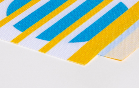 Detailansicht des Easymag Materials aus Polyester 205g mit blauen und gelben Streifen.