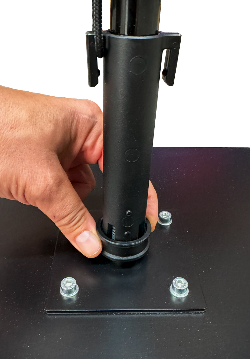 Eine Hand befestigt den Easyflag Quickconnect an einer Basisplatte mit Schrauben.